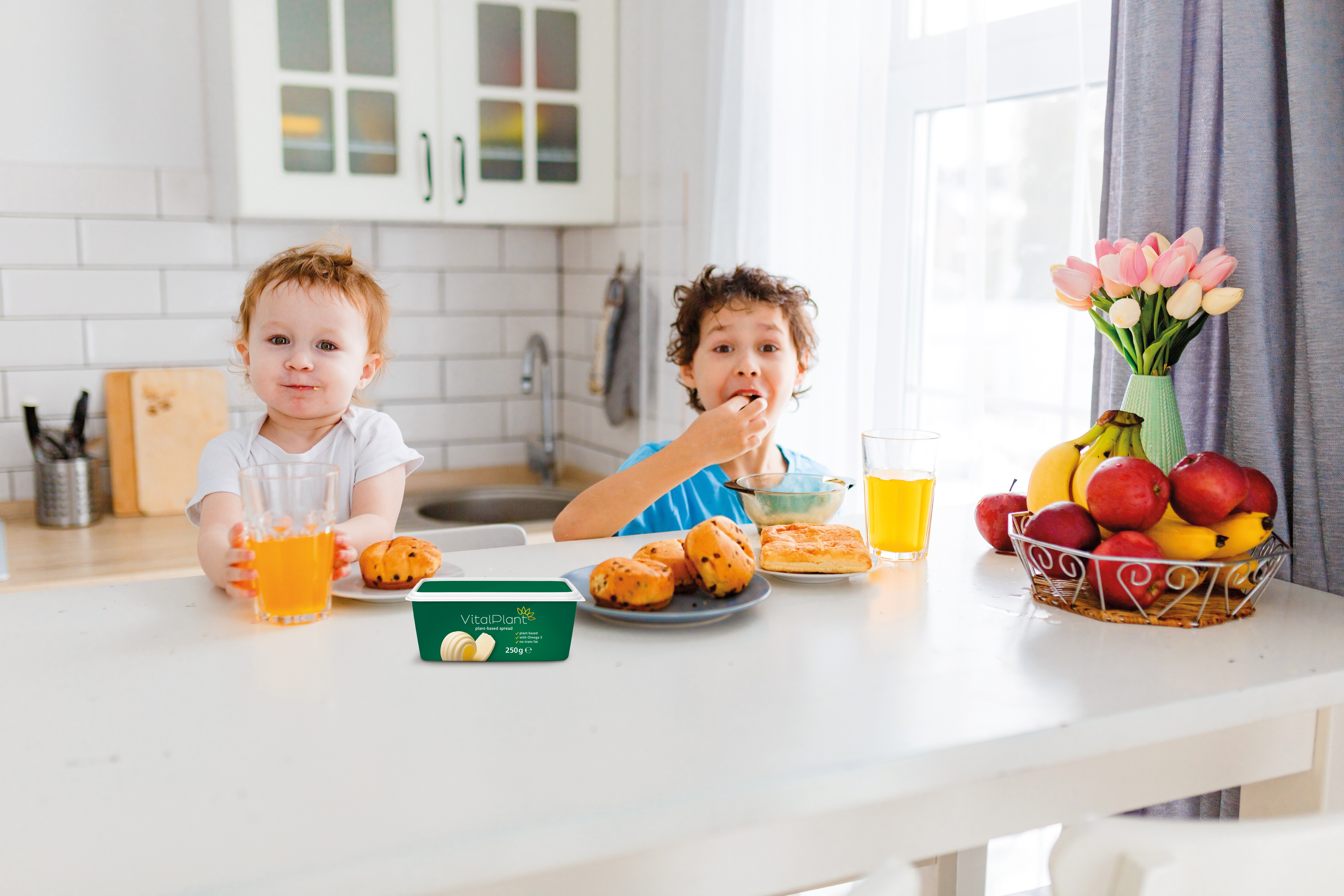Two childeren on a breakfast tabel in the background, with a green butter packaging in the foreground.